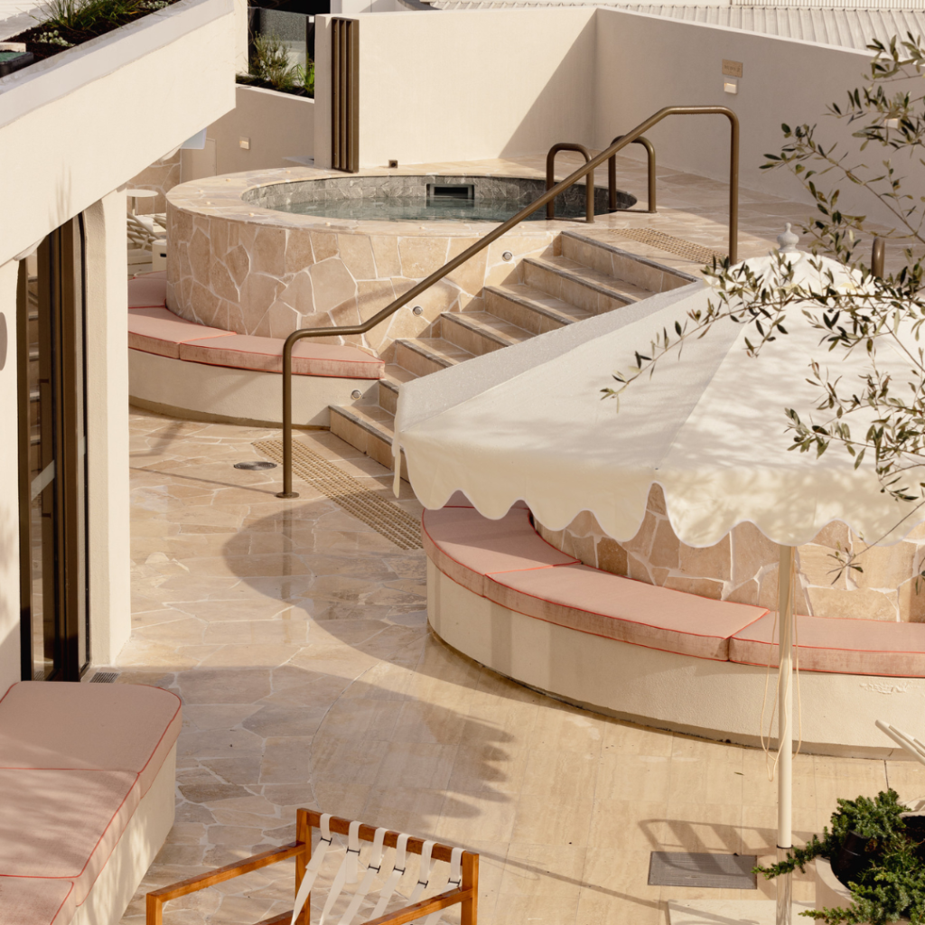Rooftop bathhouse pool with umbrella and lounge seating at TotalFusion Chermside
